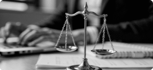 Professional portrait of a female Krayemandco criminal lawyer in a dark blazer standing in front of legal reference books.